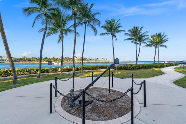 view of property's community with a lawn and a water view