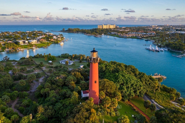 aerial view at dusk featuring a water view