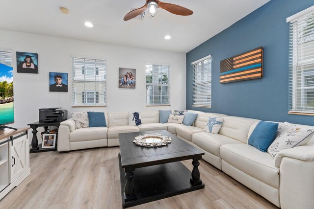 dining space with ceiling fan with notable chandelier and light hardwood / wood-style floors