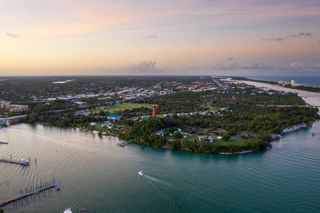 aerial view at dusk featuring a water view