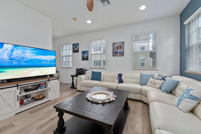 living room featuring ceiling fan, a healthy amount of sunlight, and light wood-type flooring