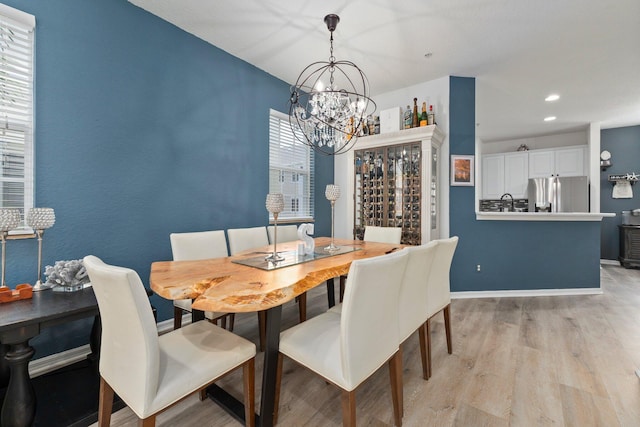 dining space featuring a notable chandelier and light wood-type flooring