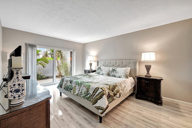 bedroom featuring a textured ceiling, light hardwood / wood-style floors, and access to exterior