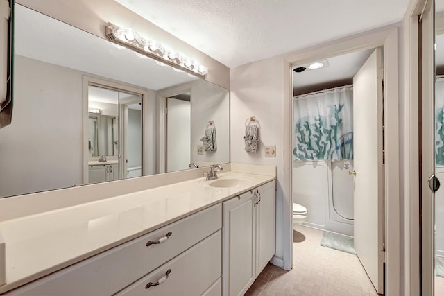 bathroom featuring vanity, toilet, and a textured ceiling