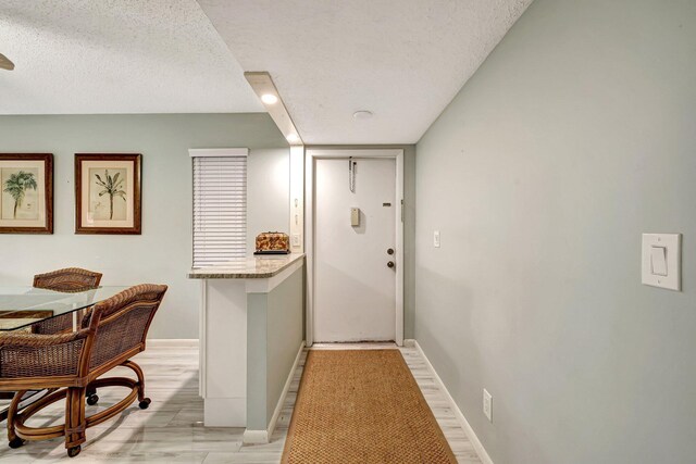 dining room with ceiling fan, a textured ceiling, and light wood-type flooring