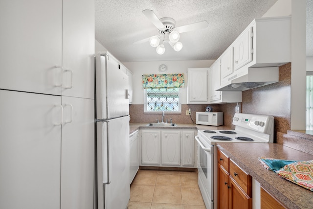 kitchen featuring white cabinetry, sink, light tile patterned flooring, and white appliances