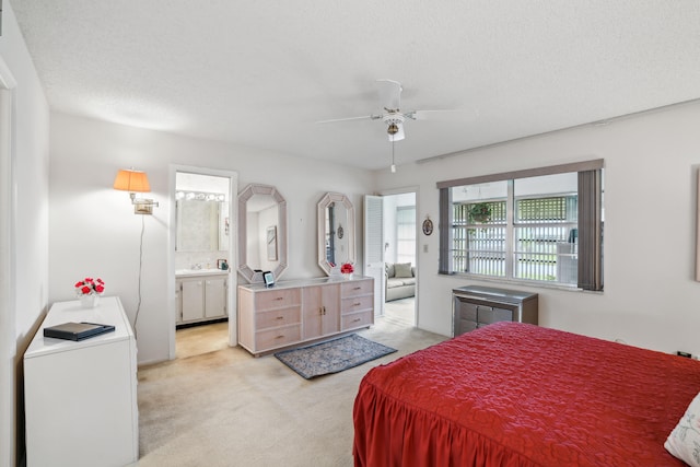 carpeted bedroom featuring ensuite bath and a textured ceiling