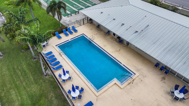 view of pool with a patio area and a lawn