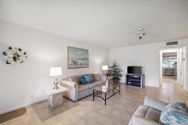 tiled living room with ceiling fan and a textured ceiling