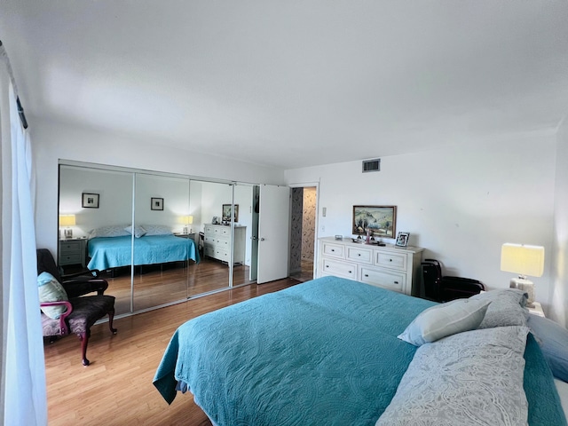 bedroom with hardwood / wood-style floors and a closet