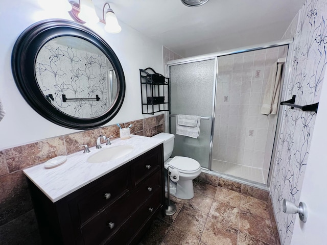 bathroom featuring vanity, toilet, and a shower with door