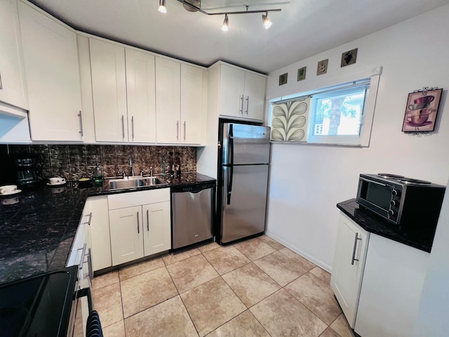 kitchen featuring white cabinetry, sink, stainless steel appliances, tasteful backsplash, and light tile patterned floors