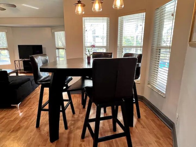 dining area featuring ceiling fan with notable chandelier and light wood-type flooring