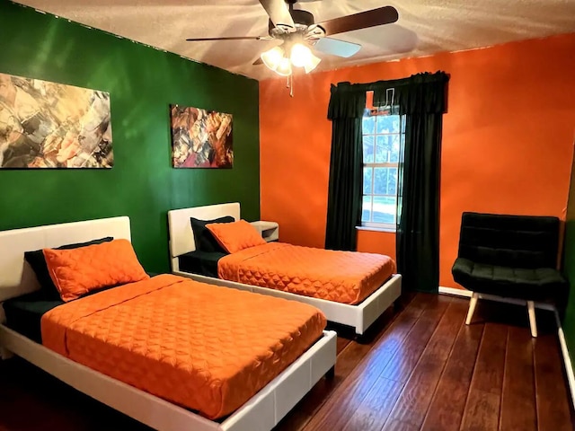 bedroom featuring ceiling fan, dark wood-type flooring, and a textured ceiling