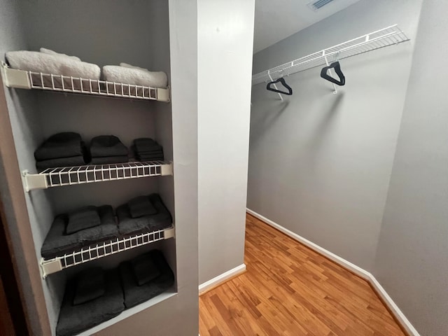 spacious closet with hardwood / wood-style flooring