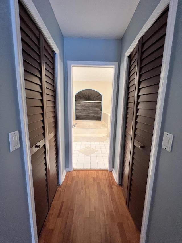 hallway with hardwood / wood-style flooring