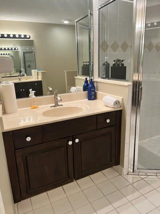 bathroom with vanity, an enclosed shower, and tile patterned floors