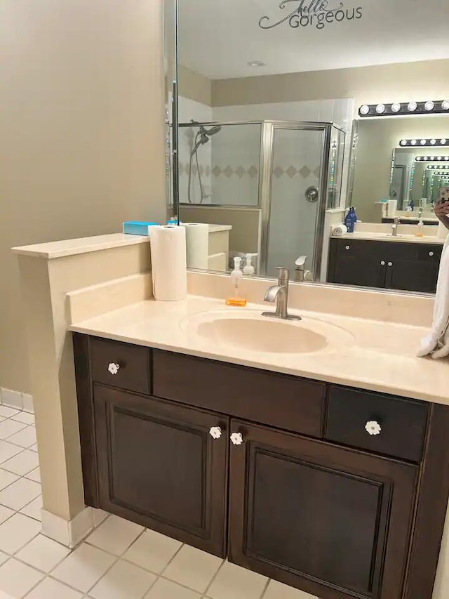 bathroom featuring walk in shower, vanity, and tile patterned flooring