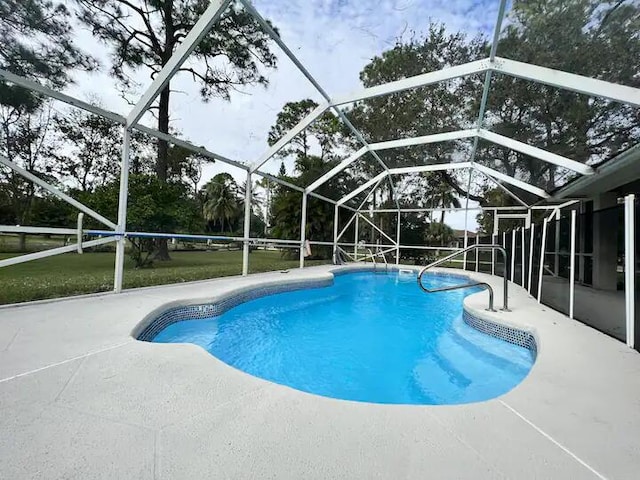 view of swimming pool featuring a lanai and a patio area