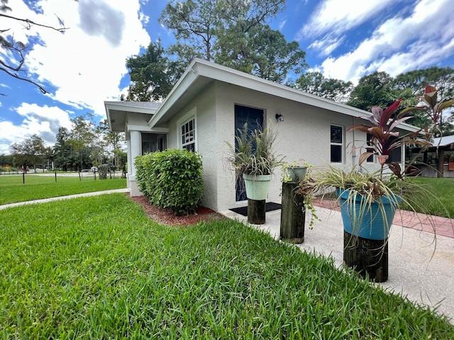 view of side of home with a yard