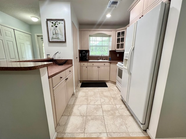 kitchen featuring white appliances, sink, and kitchen peninsula