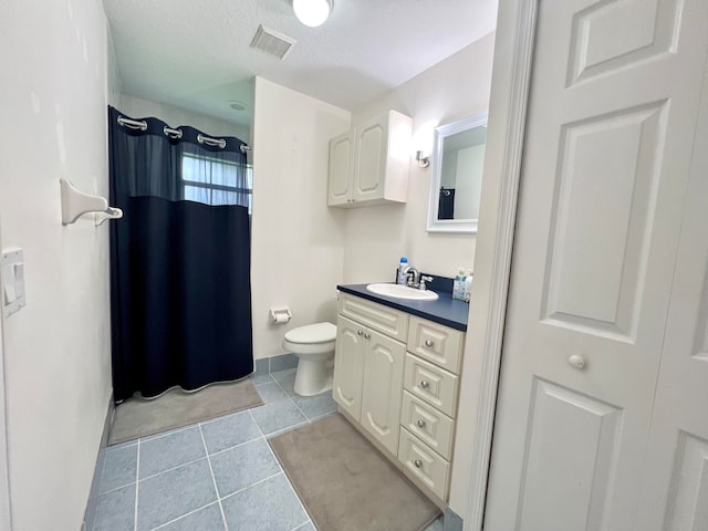 bathroom with tile patterned flooring, a textured ceiling, a shower with curtain, vanity, and toilet