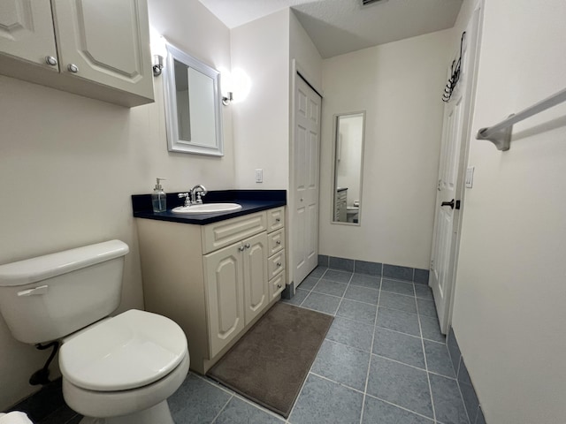 bathroom featuring vanity, toilet, and tile patterned floors