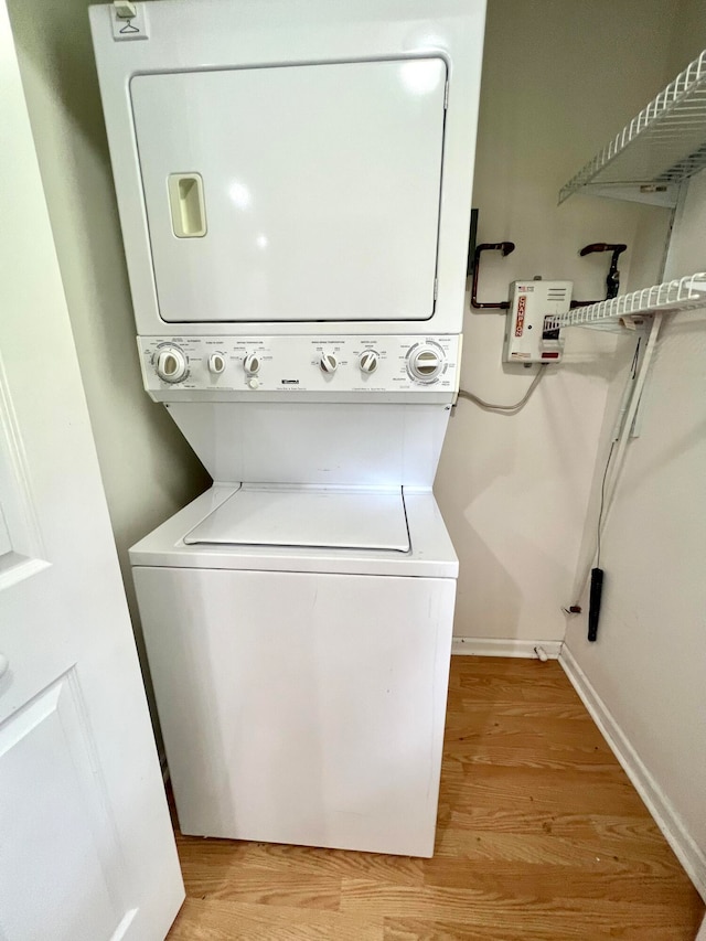 laundry area featuring stacked washer and dryer and light hardwood / wood-style floors