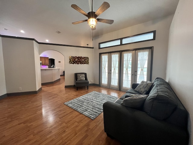 living room featuring wood-type flooring, a textured ceiling, crown molding, ceiling fan, and french doors