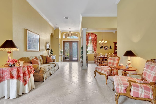 living room featuring french doors, a notable chandelier, decorative columns, and ornamental molding