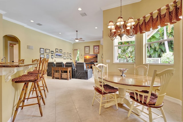 tiled dining room featuring ceiling fan with notable chandelier and ornamental molding