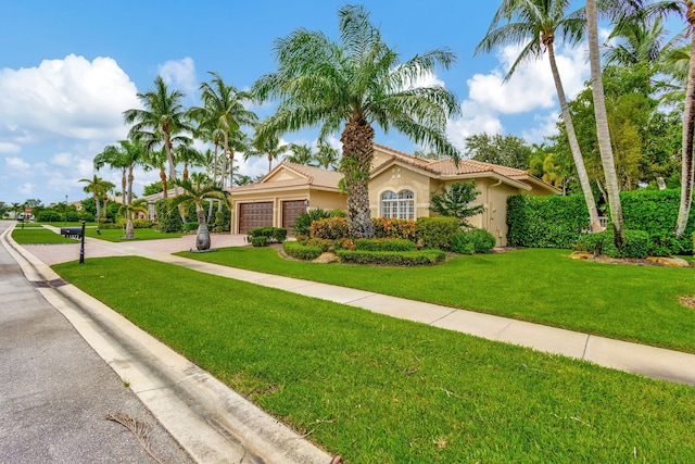 view of front of house with a garage and a front lawn