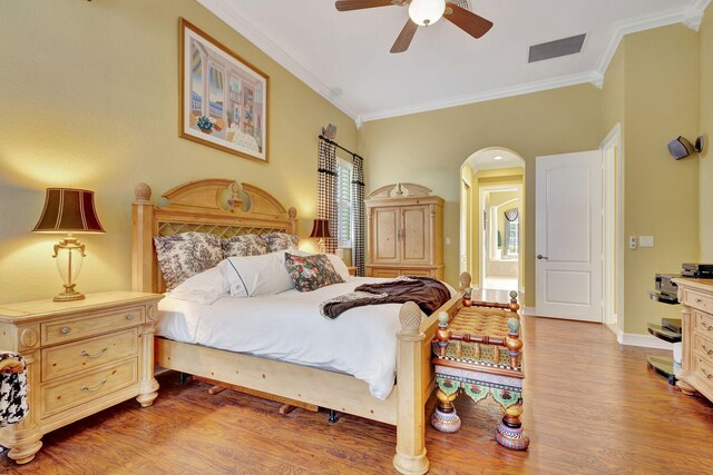 bedroom with ornamental molding, ceiling fan, multiple windows, and hardwood / wood-style floors