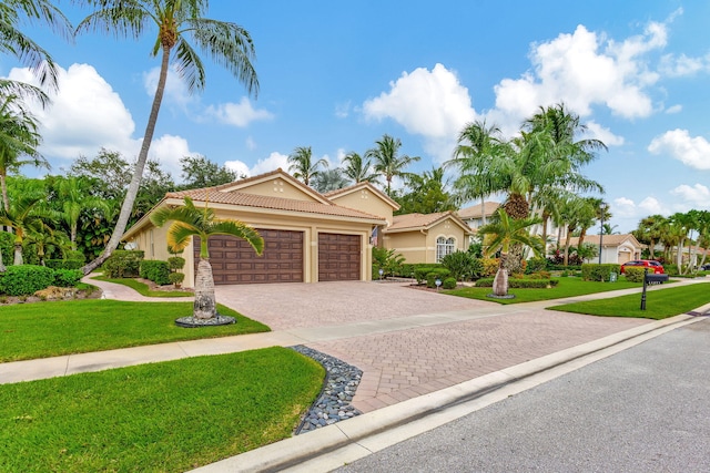 mediterranean / spanish-style home featuring a garage and a front lawn