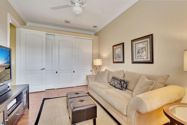 living room with ornamental molding, light wood-type flooring, and ceiling fan