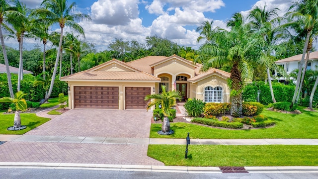 mediterranean / spanish-style home featuring a front yard and a garage