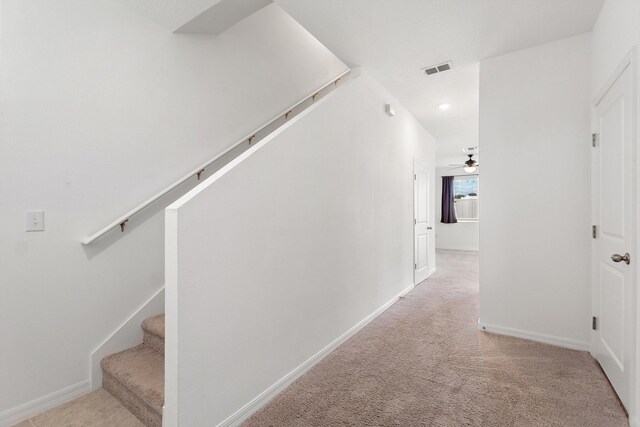 corridor featuring light colored carpet