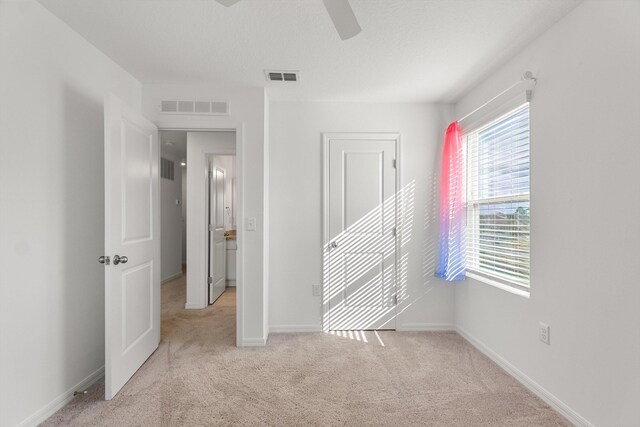 unfurnished bedroom featuring ceiling fan and light colored carpet