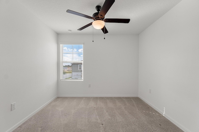 carpeted spare room featuring a textured ceiling and ceiling fan