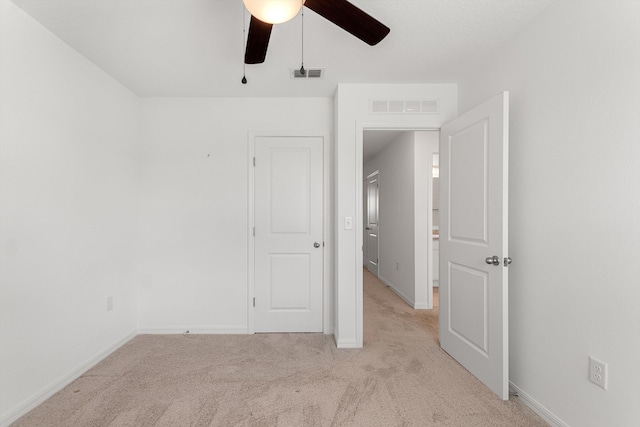 unfurnished bedroom with light carpet and ceiling fan