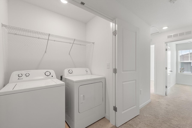 laundry area featuring light colored carpet and washer and dryer