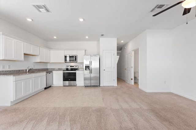 kitchen featuring ceiling fan, white cabinets, appliances with stainless steel finishes, and light carpet