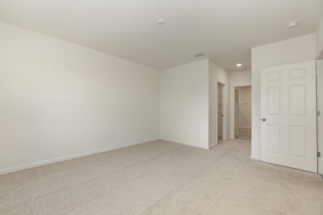 unfurnished room featuring light carpet, baseboards, and visible vents
