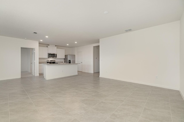 unfurnished living room with baseboards, visible vents, and recessed lighting