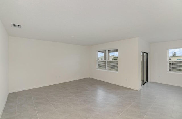 spare room featuring baseboards and visible vents