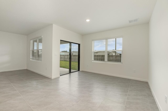 empty room with baseboards, visible vents, recessed lighting, and light tile patterned floors