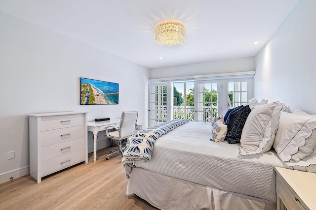 bedroom featuring a chandelier, light hardwood / wood-style floors, access to exterior, and french doors