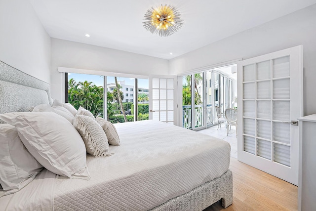 bedroom featuring light wood-type flooring, multiple windows, and access to exterior