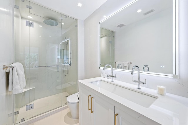 bathroom with vanity, toilet, and a shower with door