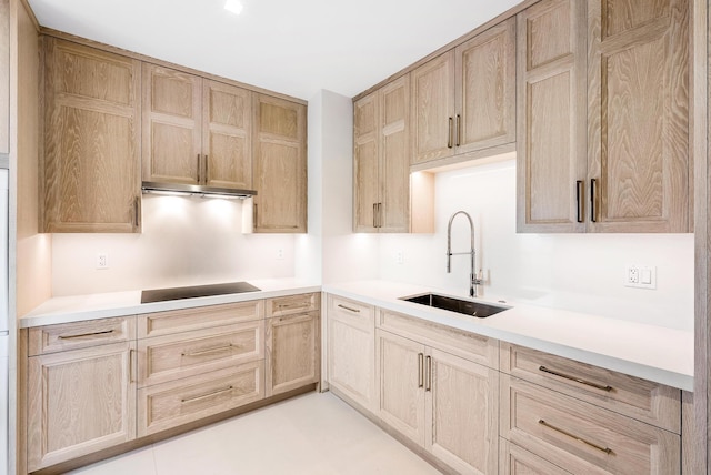 kitchen with light brown cabinetry, sink, and black electric stovetop